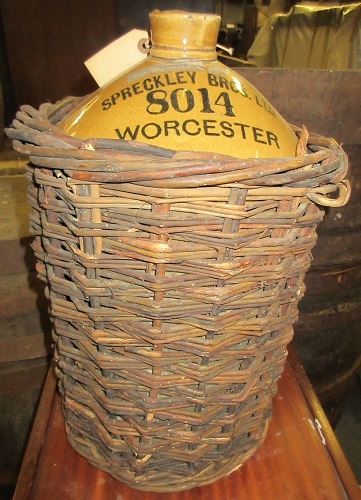 A Spreckley's demijohn still wearing its protective wicker-work jacket